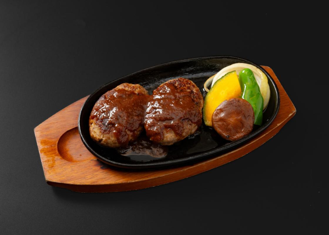 四日市市の名店・焼肉大剛の手作りハンバーグ。鉄板で焼かれる肉汁溢れるイメージ。