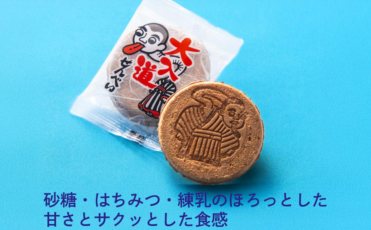 大入道の焼き印が入った丸いせんべいと、イラスト入りの個包装。サクッと優しい甘さ。
