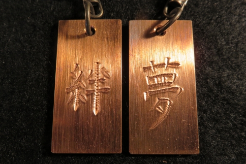 刀匠が銅板のキーホルダーに文字をお入れします。