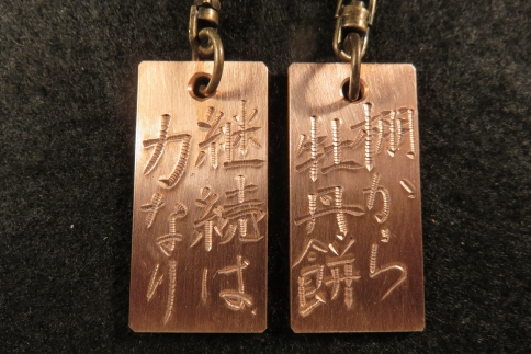 刀匠が銅板のキーホルダーに文字をお入れします。