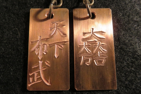 刀匠が銅板のキーホルダーに文字をお入れします。