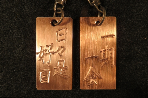 刀匠が銅板のキーホルダーに文字をお入れします。